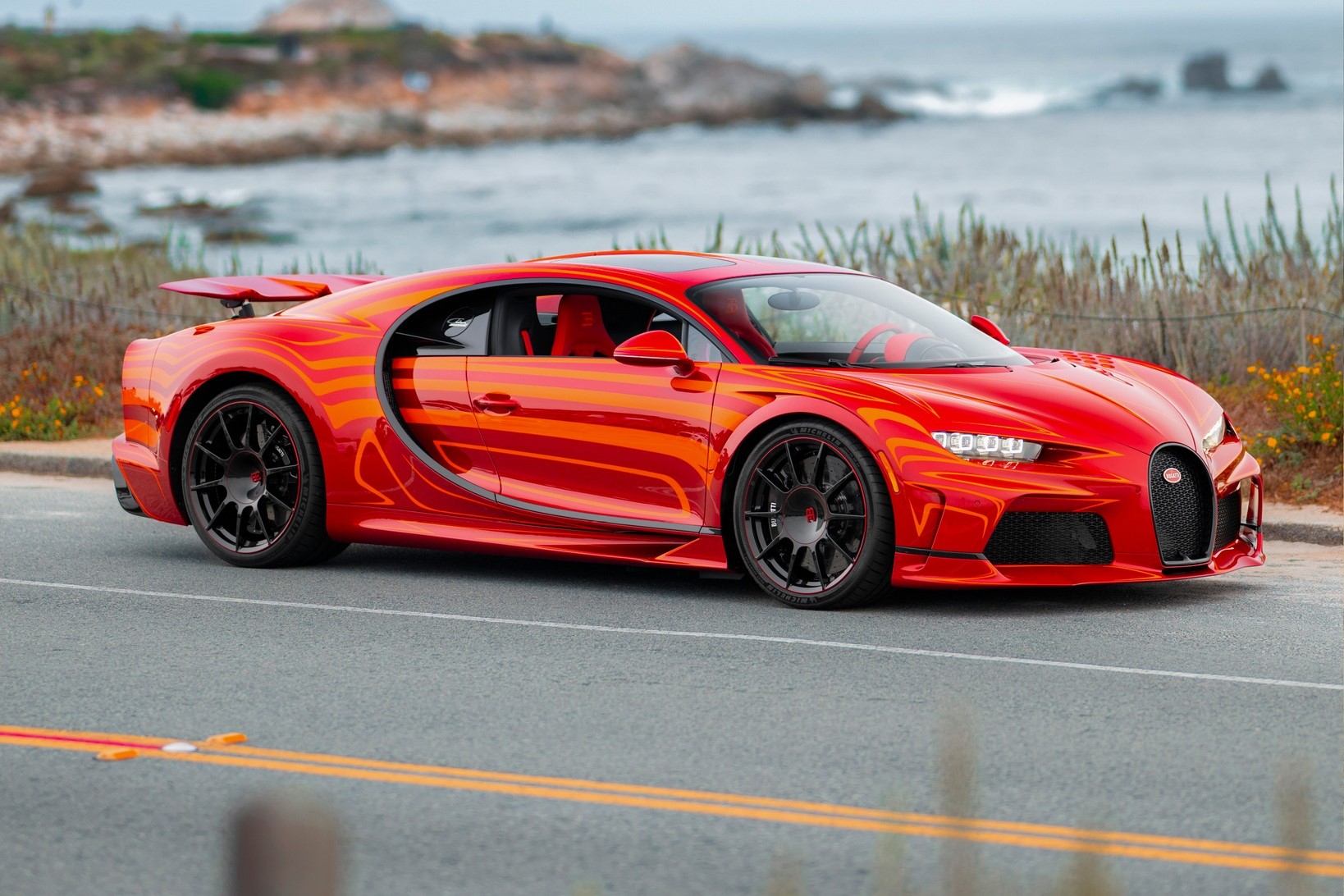 A Bugatti Chiron in a bright and orange paint that looks like fire or magma