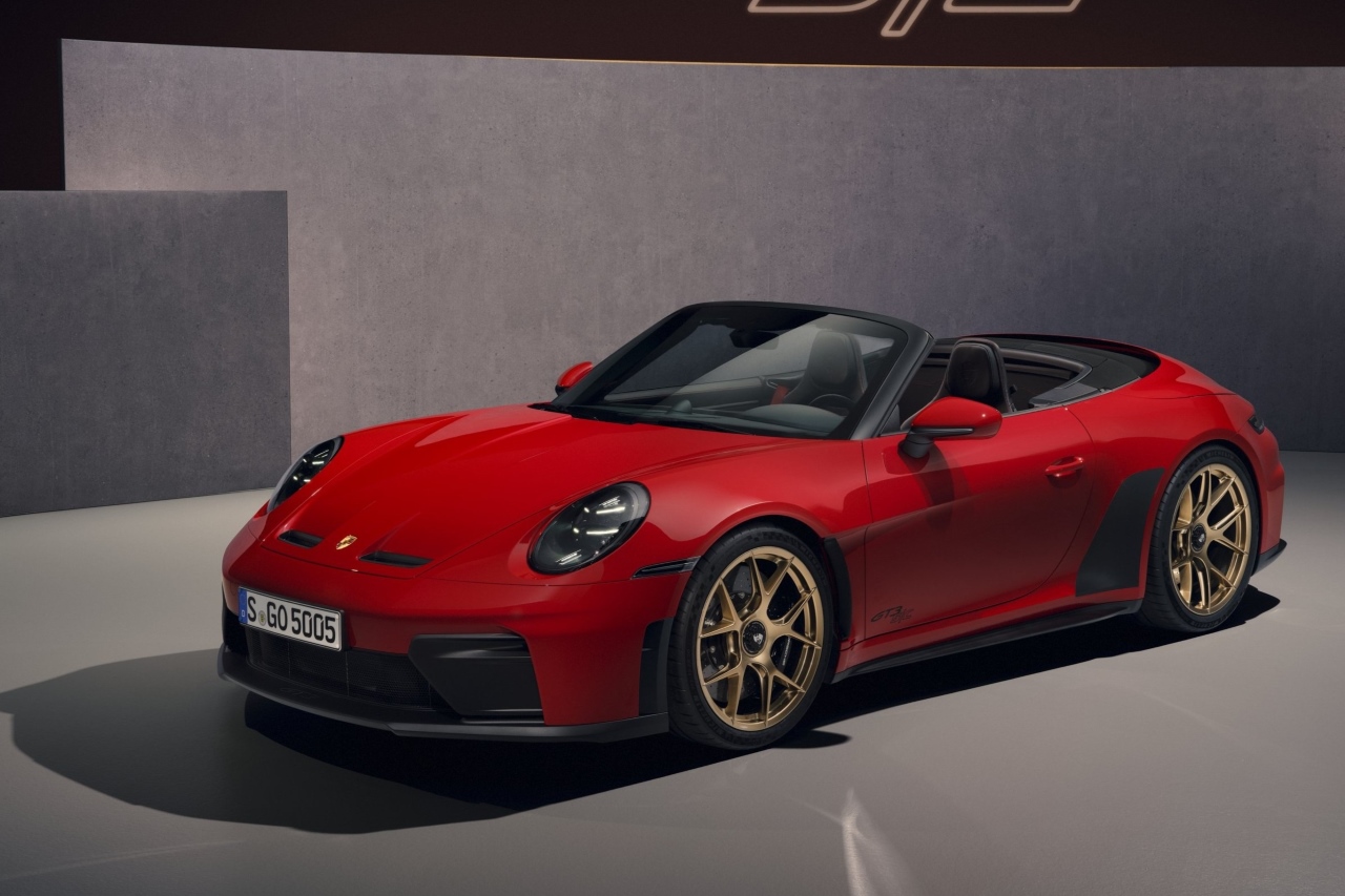 a red Porsche 911 GT3 SC convertible with golden wheel rims