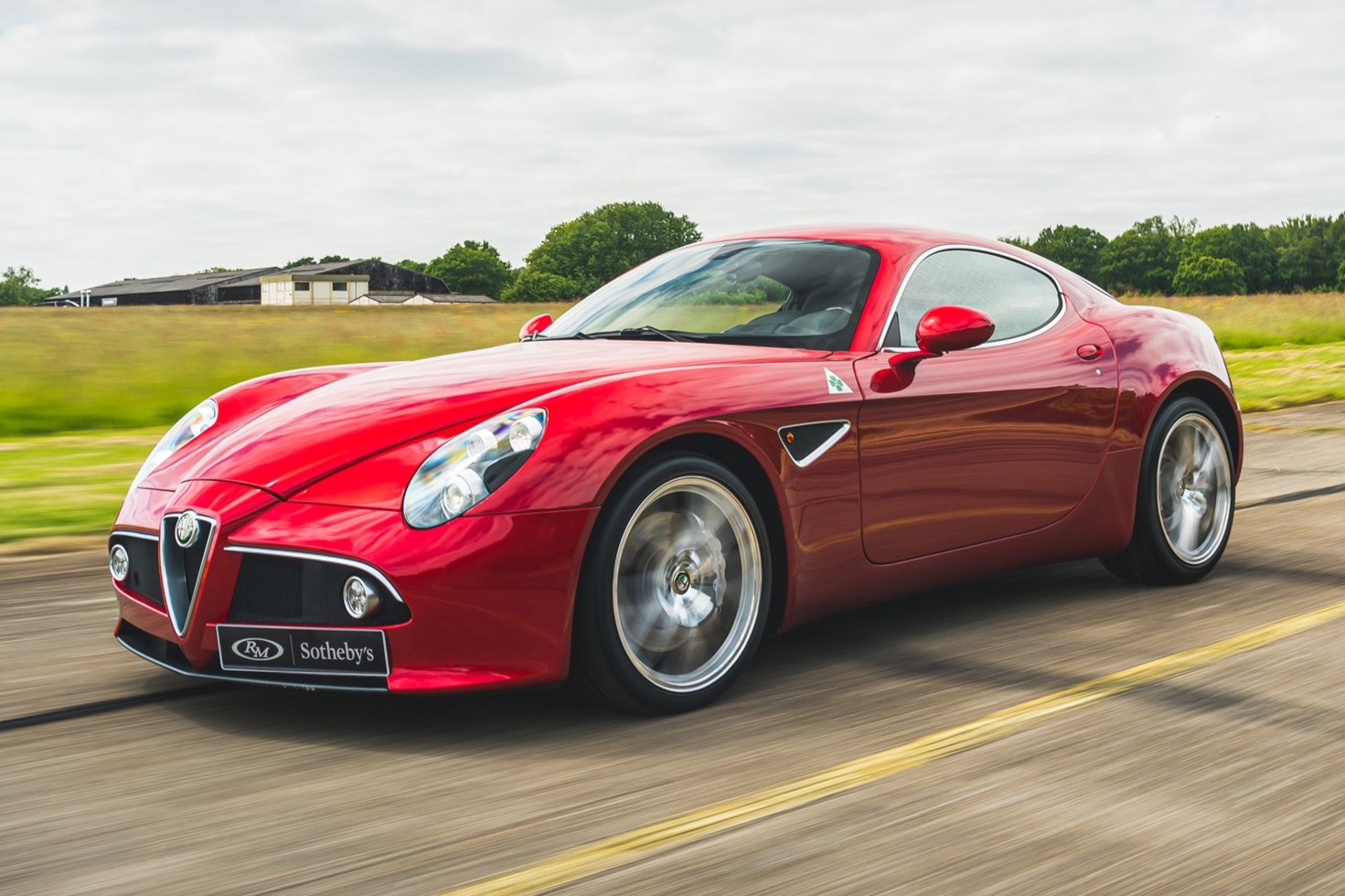 a red Alfa Romeo 8C Competizione coupe driving